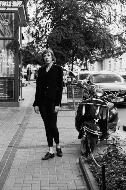 Poz şık siyah giysili genç kısa saçlı kadın              