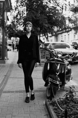 Poz şık siyah giysili genç kısa saçlı kadın              