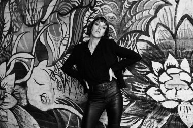 Poz şık siyah giysili genç kısa saçlı kadın              