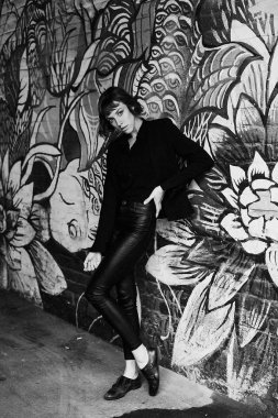 Poz şık siyah giysili genç kısa saçlı kadın              