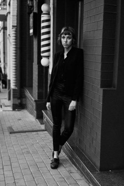 Poz şık siyah giysili genç kısa saçlı kadın              