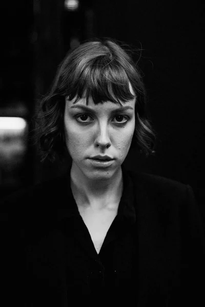 Young short haired woman in stylish black clothes posing