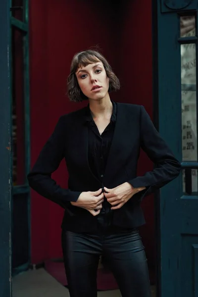 Young short haired woman in stylish black clothes posing