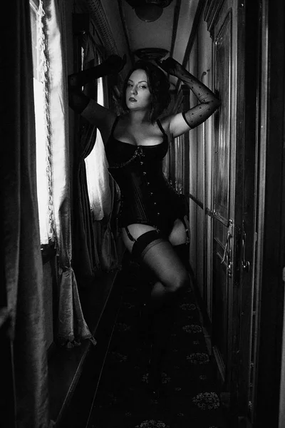 美丽的性感的女人在黑色内衣和丝袜摆在室内 — 图库照片