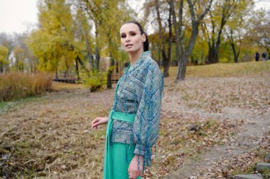 Muhteşem bir genç esmer kadın açık havada poz 