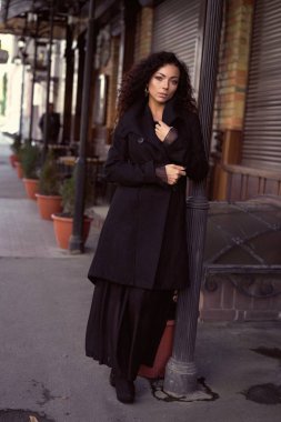 kıvırcık saçlı posig olan güzel kadın