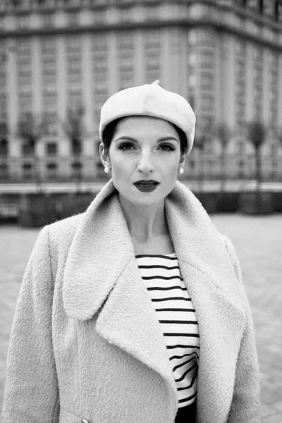 Gorgeous young woman in coat and beret