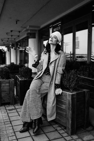 Eski moda elbiseli genç bir kadın sigara içiyor. 