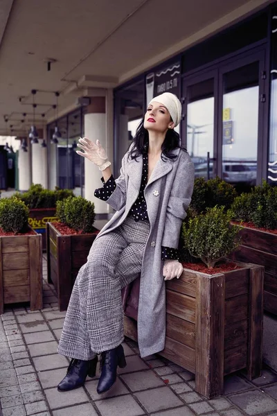 Eski moda elbiseli genç bir kadın sigara içiyor. 