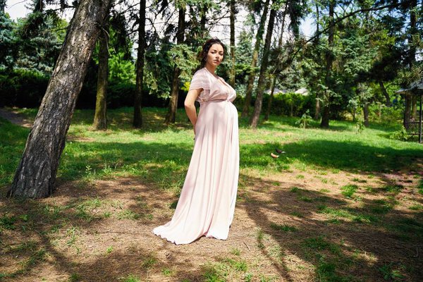 Gorgeous pregnant woman in summer park