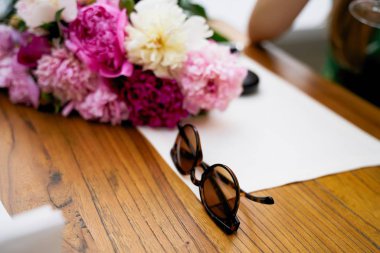 Masada şakayık çiçekleri ve güneş gözlüğü var. 