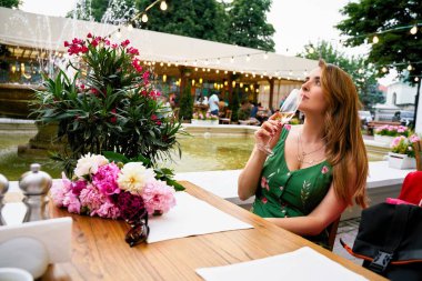 Young woman drinking champagne in outdoor cafe