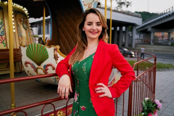 Yeşil Elbise Kırmızı Ceketli Güzel Genç Kadın Sokakta Poz — Stok fotoğraf