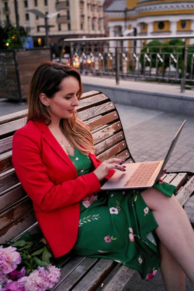 Stock image Young beautiful woman using laptop while sitting on park bench