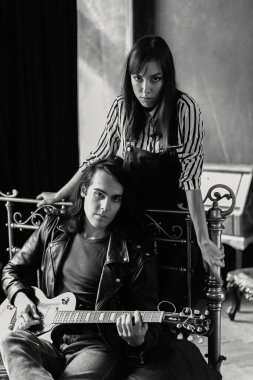 Kanepede gitar çalan genç bir çift.