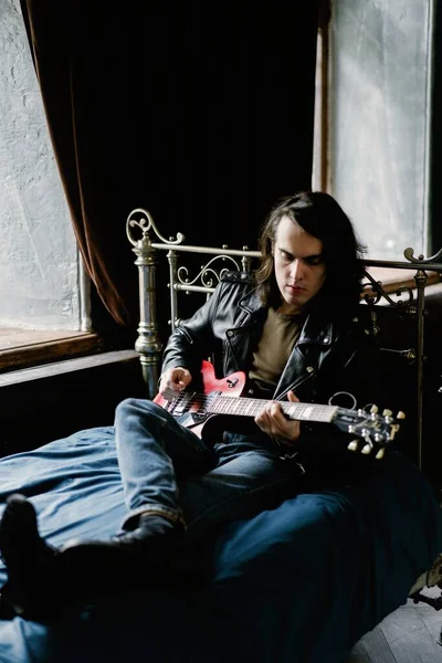 Gitar çalan genç adam