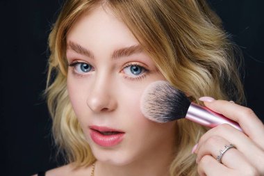 güzel bir genç kadın makyaj uygulamak 
