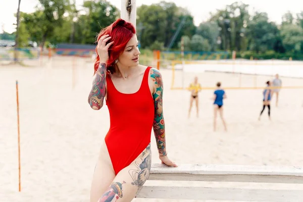在海滩上穿着泳衣的漂亮的纹身女青年 — 图库照片