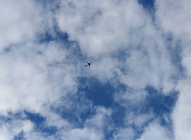 uçak bulutlu gökyüzüne yükselir