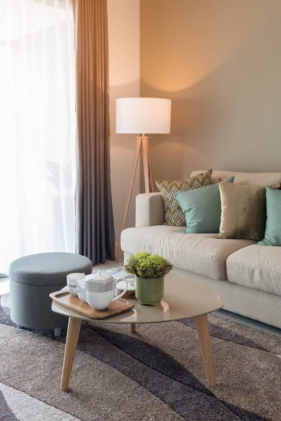 rahat oturma odası cam kapı sabah, iç dekorasyon tasarım konsepti tablo ve güneş ışığı etkisi bardakta çay seti ile