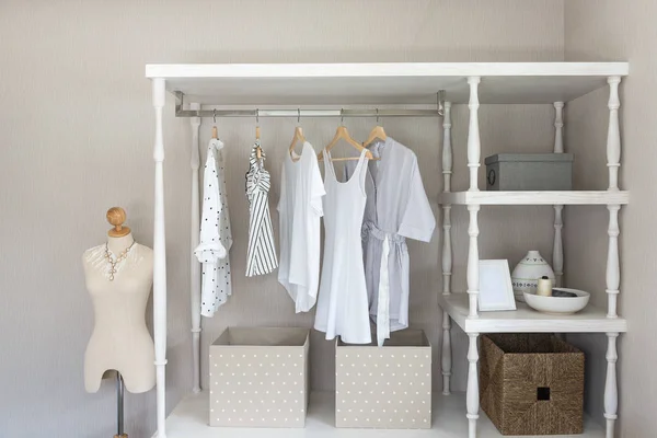white color shirts hanging on rail in classic style wooden closet, interior design concept