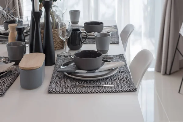 white modern table set on wooden dining table in modern dining room, interior design concept