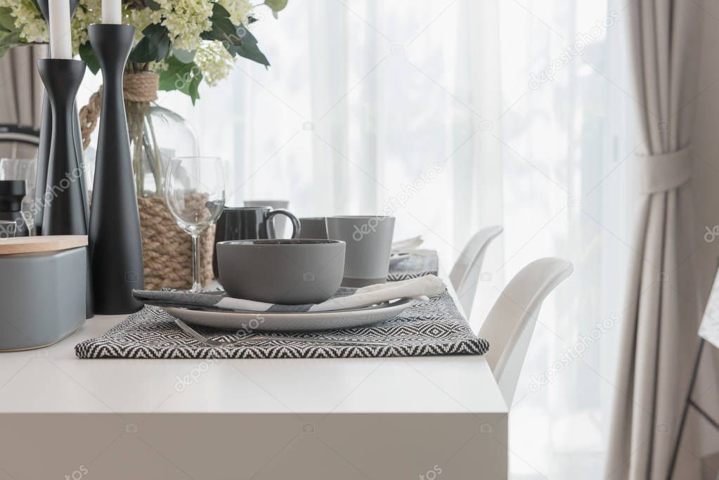 white modern table set on wooden dining table in modern dining room, interior design concept