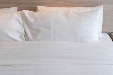 Ahşap yatak ve beyaz renk tonu yastıklar, iç tasarım dekorasyon konsepti dizi modern yatak odası