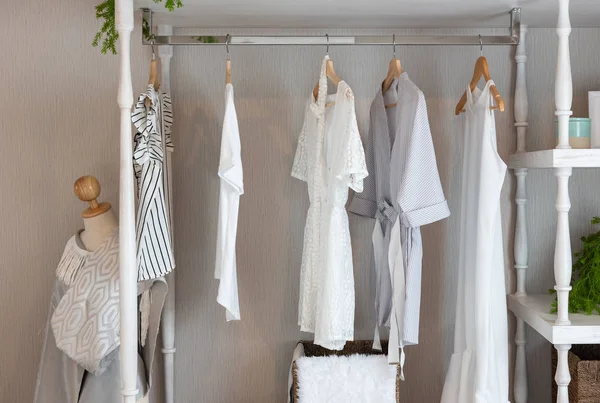 classic closet style with clothes hanging, white color tone wardrobe with clothes, interior decoration design concept