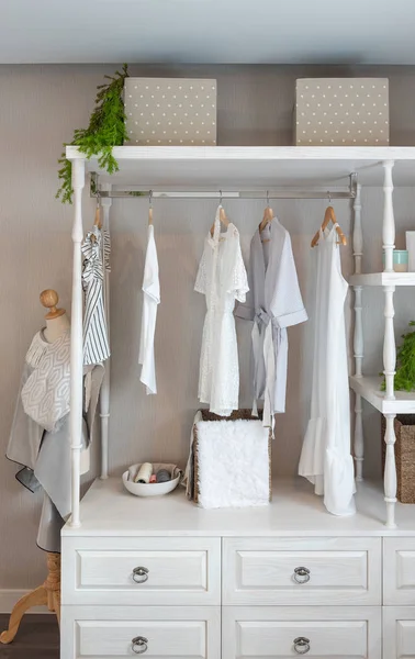 classic closet style with clothes hanging, white color tone wardrobe with clothes, interior decoration design concept