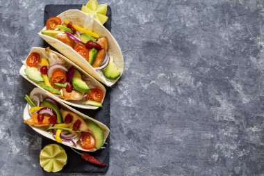 Meksika yemeği tacos, kızarmış tavuk, yeşil, avokado, biber, kırmızı lahana ve ekmeği koyu arka plan üzerinde avokado