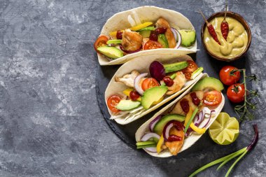 Meksika yemeği tacos, kızarmış tavuk, yeşil, avokado, biber, kırmızı lahana ve ekmeği koyu arka plan üzerinde avokado