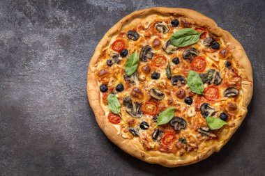 Pizza domates, peynir, mantar, zeytin ve ıspanak karanlık bir arka plan üzerinde