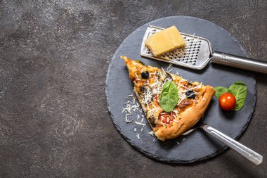 Pizza domates, peynir, mantar, zeytin ve ıspanak karanlık bir arka plan üzerinde