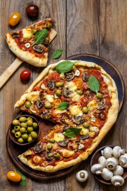 Pizza mantar, domates, zeytin ve Ispanaklı ve keçi peynirli ahşap arka plan üzerinde
