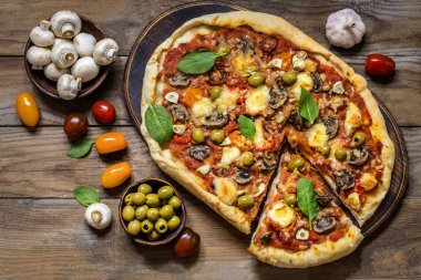 Pizza mantar, domates, zeytin ve Ispanaklı ve keçi peynirli ahşap arka plan üzerinde