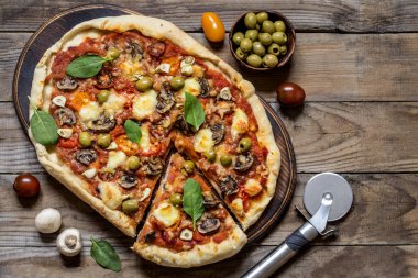 Pizza mantar, domates, zeytin ve Ispanaklı ve keçi peynirli ahşap arka plan üzerinde