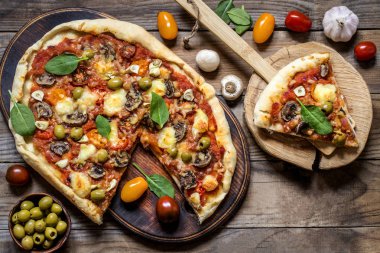Pizza mantar, domates, zeytin ve Ispanaklı ve keçi peynirli ahşap arka plan üzerinde