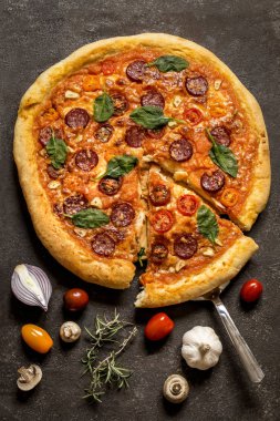 Salam sosis, ıspanak ve kiraz domates ve salça koyu arka plan üzerinde pizza