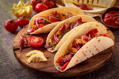 ahşap bir Tahta üzerinde tavuk, biber, domates, lahana ve salsa ile tacos Meksika gıda