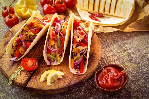 ahşap bir Tahta üzerinde tavuk, biber, domates, lahana ve salsa ile tacos Meksika gıda