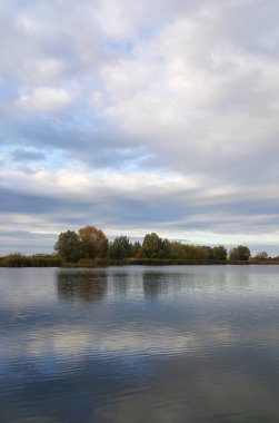 Bulutlu öğleden sonra gölün uzak sahil