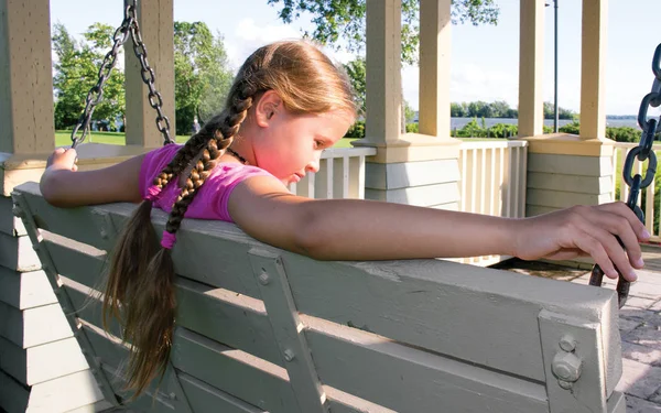 Szomorú, álmodozó, látszó lány ül a swing pad a parkban — Stock Fotó