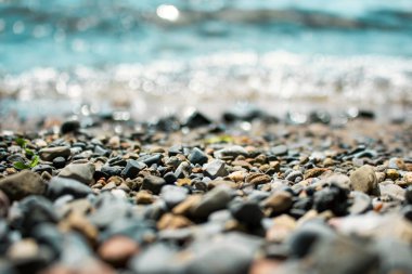 Dalgalar, çakıl plaj üzerinde yıkama makro dar odak arka plan ile vurdu.
