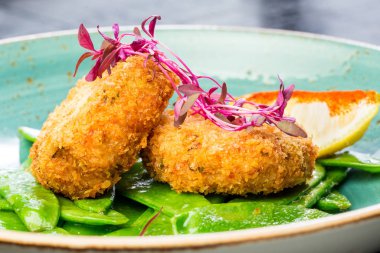 Ekmek kırıntıları, yeşil biber ve limon ile yengeç pirzola