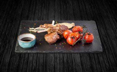 fırında domatesli kuzu kaburga. Ahşap bir masaya