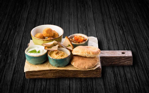 Siyah ahşap zemin üzerine ahşap tahta üzerinde çeşitli aperatifler