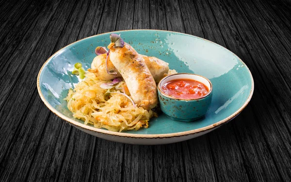 Tavuk sosis lahana turşusu ve sos ile. Ahşap bir masaya