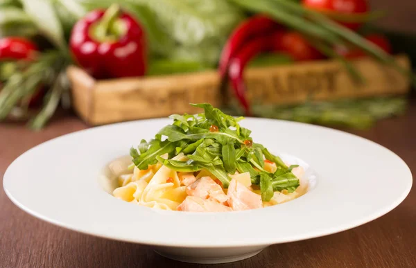 Kırmızı havyar ve roka ile füme somon ile fettuccine makarna. Bir beyaz plat