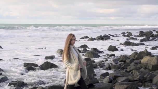 Una Joven Con Abrigo Elegante Camina Por Playa Admirando Una — Vídeos de Stock